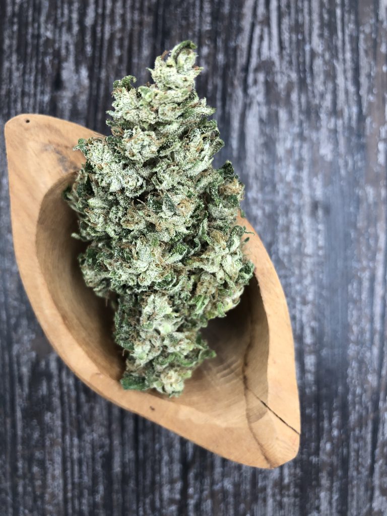 a hemp flower bud displayed in a wooden bowl